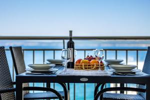 a table with a basket of fruit and a bottle of wine at Apartmani Heta Alagic I in Selce