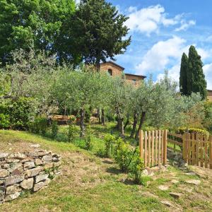 a garden with trees and a wooden fence at casa vacanze nel Chianti il Granaio in Castellina in Chianti