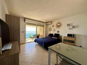 a bedroom with a bed and a view of the ocean at Studio vue mer limitrophe à Monaco in Roquebrune-Cap-Martin