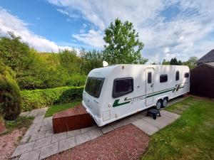 a white rv parked in a yard at Railway cottage caravan in Oban