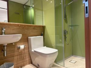 a bathroom with a toilet and a sink and a shower at Sky Suites City Centre in Kuala Lumpur