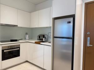a kitchen with white cabinets and a stainless steel refrigerator at Sky Suites City Centre in Kuala Lumpur +29 photos