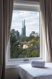 una ventana con vistas a la ciudad desde una habitación de hotel en Lily Sands Inn, en Melbourne