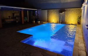 a swimming pool at night with blue lighting at Casa de São Pedro in São Pedro