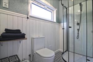 a bathroom with a shower and a toilet and a window at Oddech in Miłków