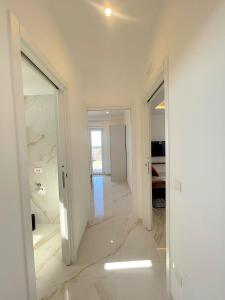 a hallway with white walls and white marble floors at Rooftop Galatina in Galatina