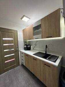 a kitchen with a sink and wooden cabinets at Apartament la casă in Bistriţa