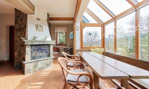 a dining room with a table and a fireplace at Willa Widok in Szczyrk
