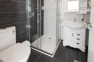een badkamer met een toilet, een douche en een wastafel bij Lily Sands Inn in Melbourne
