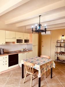 una cucina con tavolo con due sedie e lampadario a braccio di Villa La Passione Charme House a Venarotta