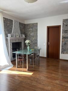 a dining room with a table with chairs and a fireplace at Charming & bright apartment Como lakefront in Argegno