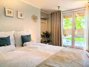 a bedroom with a large white bed and a window at SB Apartment with Sauna in Kołobrzeg