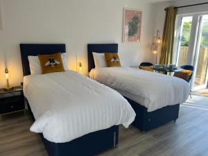 a bedroom with two beds and a table at Tree View Studio in Ballycastle