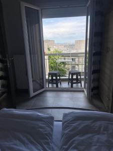 a bedroom with a bed and a balcony with tables at LIKE a Home in Thessaloniki in Thessaloniki +24 photos