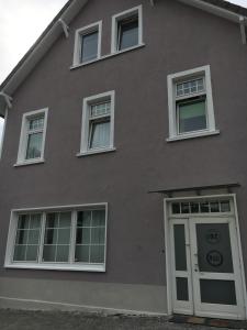 una casa gris con ventanas blancas y una puerta en Rael-Boardinghouse en Bielefeld