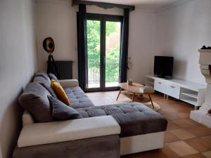 a living room with a couch and a tv at Belle maison proche du futuroscope in Thuré