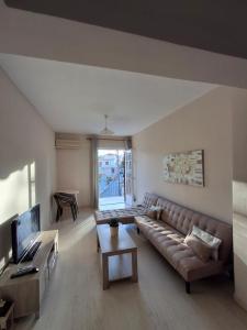 a living room with a couch and a television at Tasias apartments in Lixouri