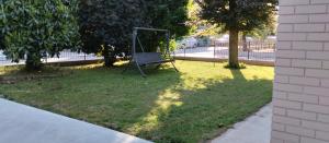 a park with a swing in the grass at wagner 11 in Faenza