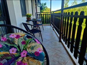 a balcony with a bench and chairs on a porch at Rebeka Luxury Apartment in Tryavna