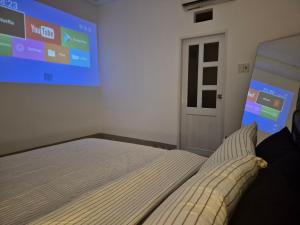 una camera con un letto e un grande schermo di An Home - Phòng đơn ngay bãi sau Vũng Tàu a Vung Tau