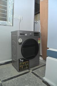 een magnetron zittend op de vloer naast een muur bij Modern 1 BHK in Kondapur in Prime Location #103 in Kondapur