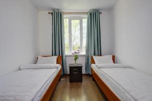 two beds in a room with a window at Частный сектор in Bosteri
