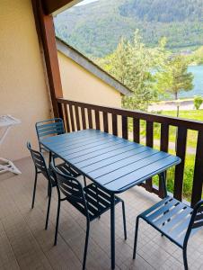 a blue table and chairs on a balcony with a view at Appt T3 calme bord du lac avec piscine in Loudenvielle