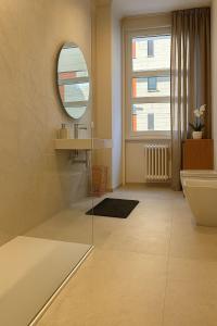 a bathroom with a tub and a sink and a mirror at Giselda Suite - Oval in Turin +51 photos