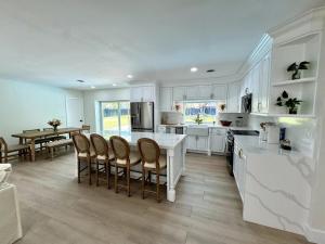 a kitchen with white cabinets and a table and chairs at Chic-ness Oasis in Cutler Bay