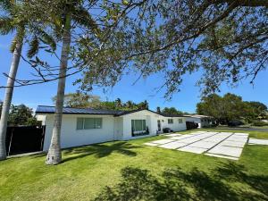 a house with a yard with palm trees at Chic-ness Oasis in Cutler Bay
