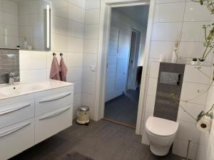 a white bathroom with a toilet and a sink at Villa Borgholm - Öland in Borgholm +10 photos