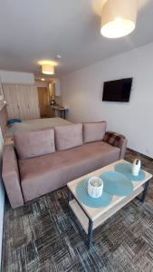 a living room with a couch and a table at Apartament Sand Welle in Grzybowo