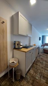 a kitchen with white cabinets and a counter top at Apartament Sand Welle in Grzybowo