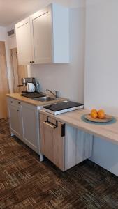 a kitchen with a counter top with oranges on a plate at Apartament Sand Welle in Grzybowo +18 photos