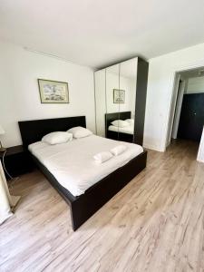 a bedroom with a large bed with two pillows at The golden triangle Apartment in Deauville