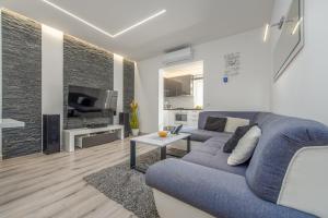 a living room with a blue couch and a fireplace at Floyd in Bibinje