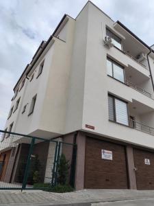 a large white building with a garage at Darena apart in Stara Zagora