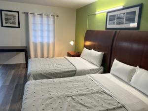 a hotel room with two beds and a window at Travel In in Ridgeway