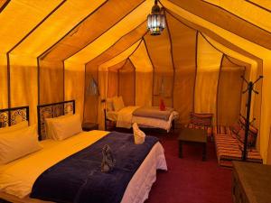 A bed or beds in a room at Luxury Merzouga Desert Camp