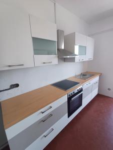 a kitchen with white cabinets and a wooden counter top at Odeon A near Basel in Huningue