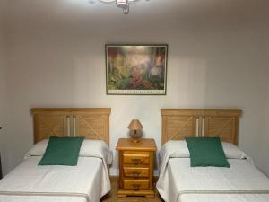 Zimmer mit 2 Betten und einem Bild an der Wand in der Unterkunft Casa Rural Arco Antico in Navahermosa + 10 Fotos
