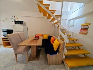 a room with a table and a couch under a staircase at Apartment Neva with Terrace in Baška