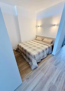 una camera da letto con un letto nell'angolo di una stanza di Pied a terre Coralli a Marina di Portisco