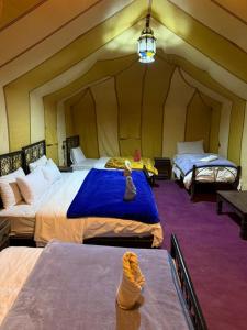 A bed or beds in a room at Luxury Merzouga Desert Camp