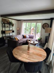een woonkamer met een tafel en een bank bij Bungalow in het bos in Nunspeet