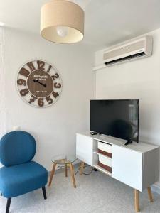 salon z telewizorem i niebieskim krzesłem w obiekcie Fantastic Seaview Apartment w Alicante