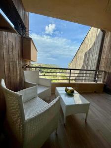 balcone con sedie, tavolo e vista di Pied a terre Coralli a Marina di Portisco