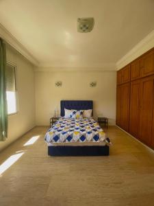 a bedroom with a bed with a blue comforter at Villa à louer nouaceur 3 chambres in Nouaseur