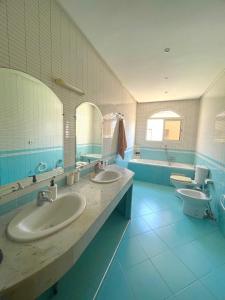 a large bathroom with two sinks and two toilets at Villa à louer nouaceur in Nouaseur