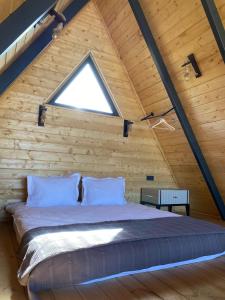 a bed in a wooden room with a window at Sapancalostbungalow in Feyziye
